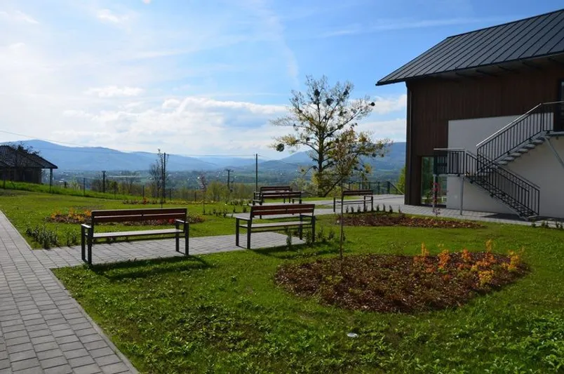 Ogródek z ławkami, ścieżkami i widokiem na góry